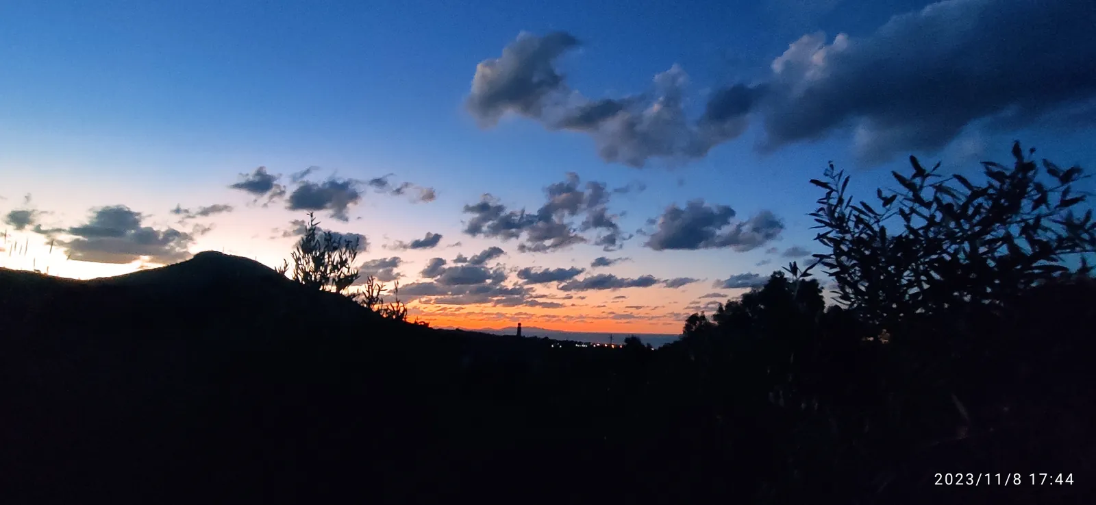 Tramonto sulle colline con il mare all'orizzonte