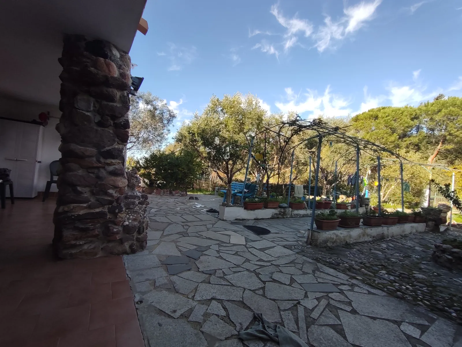 Veranda coperta con pilastri in pietra e pavimento in lastre di granito